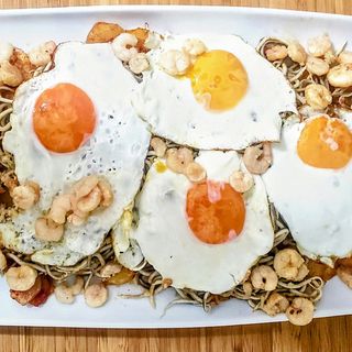 Pincho de gulas y gambas sobre huevo frito
