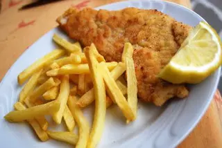 Cotoletta di pollo con patate fritte e limone