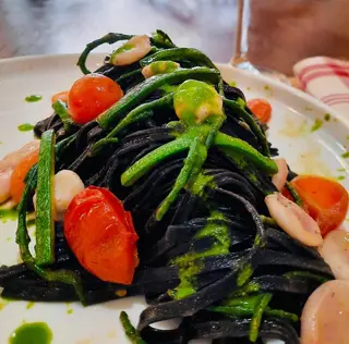 Tagliolini al nero di seppia, salsa alla salicornia, calamari, pomodoro e zucchine