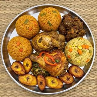 Jollof rice, fried rice, plantains, deep fried chicken and goatmeat 
