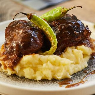 Carrilleras de Cerdo con reducción de Vino tinto, puré de Patata y Piparras