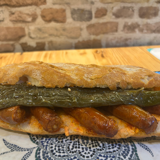 Bocadillo de txistorra con pimientos fritos y tomate restregado. 