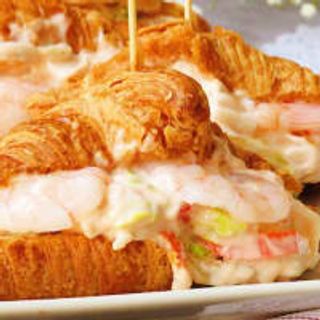 Croissant Seúl (1ud) Gambas, Cebolla pochada Salsa suave Hojas Verdes.