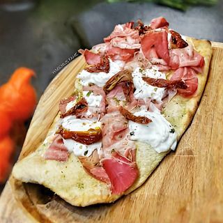 Pinsa con burrata, pomodori secchi e prosciutto crudo