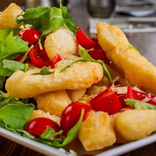 Chiacchiere fritte con pomodorini freschi, rucola e grana