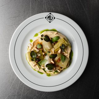 20 Porros a la brasa amb hummus i vinagreta de tomàquet semisec i alfàbrega