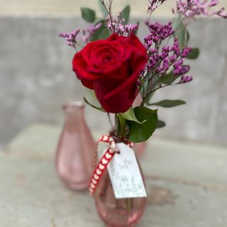 Rosa roja en botella de cristal pequeña