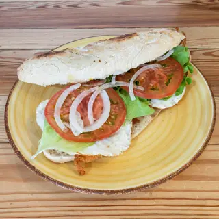 Bocata de pollo rebozado con queso, huevo, lechuga, tomate y cebolla