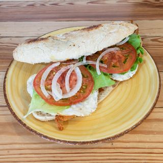 Bocata de pollo rebozado con queso, huevo, lechuga, tomate y cebolla