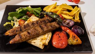 Kebab Adana servit cu sos de ardei lipie si cartofi prajiti