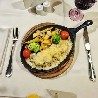 Телятина з грибами під сиром з броколі, томатами та дольками картоплі