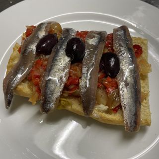 Coca de escalivada con anchoas y aceitunas de Kalamata
