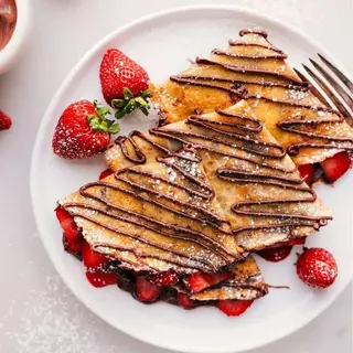two pieces of banana/strawberry/plain crepes served with a fruit bowl