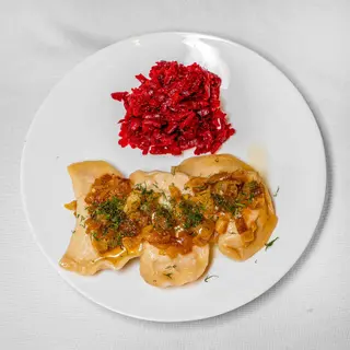 Pierogi z kapustą i grzybami 7 szt. okraszone smażoną cebulką.
