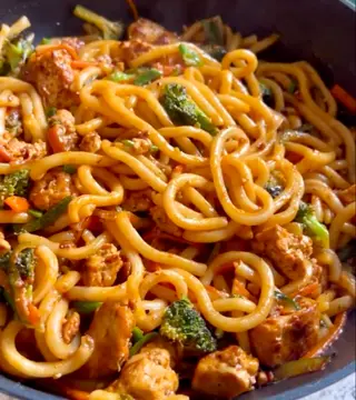 Noodles con ragù di pancetta, verdure e arachidi