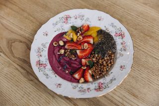 Грецький йогурт з цільною пшеницею, манго, ягідним кулі, медом та ягодами