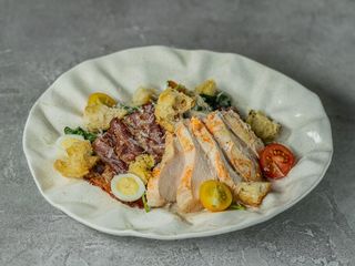 Цезар з куркою су-від, беконом, перепелиними яйцями та пармезаном