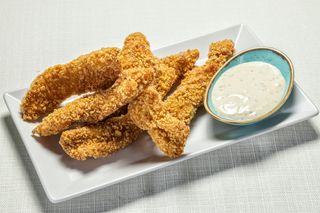 Хрупкави пилешки пръчици с млечночеснов сос (200г)