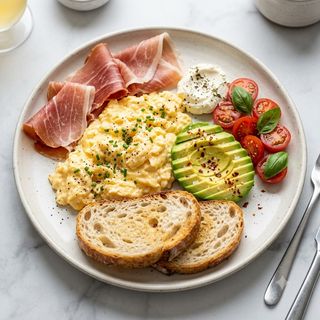Plato De Huevos Con Aguacate, Tomate, Crema De Queso, Jamón Y Pan