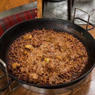 Paella con pollo, butifarra y alcachofas