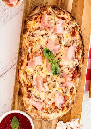 Pizza prosciutto y fungui.