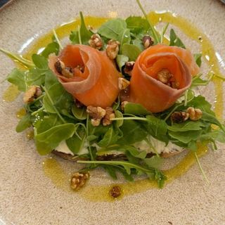 Tostada de salmón, crema de queso, rúcula y nueces