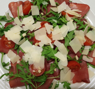 Carpaccio di bresaola con rucola, pomodorini e scaglie di grana
