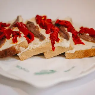 Tostada de crema de roquefort, pimiento de piquillo y anchoas