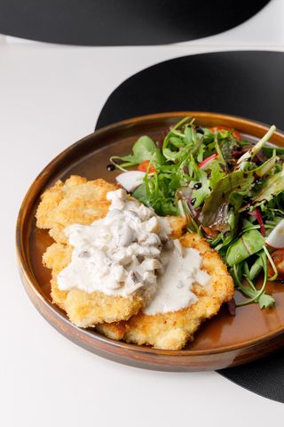 Schnitzel din fileu de pui cu salată și sos de ciuperci