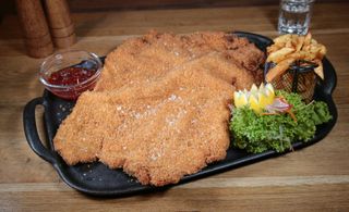 Snitel gigant cu dulceata de ardei iute si cartofi prajiti