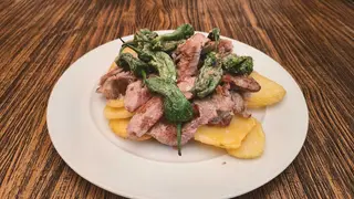 Pluma Iberica Con Patatas Fritas Y Pimientos Del Padrón