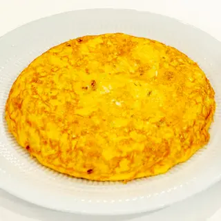 Tortilla melosa de patatas y cebolla pochada.