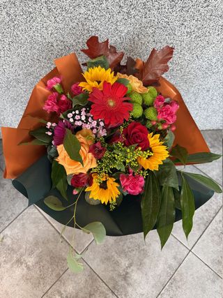 Bukiet 9 kolorowych mieszanych kwiatów, w tym sezonowych z  przybraniem w ozdobnej kryzie ze wstążką
