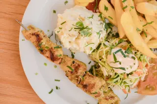 Pincho Moruno de Cerdo Especiado con Ensaladas Alemanas y Papas Fritas