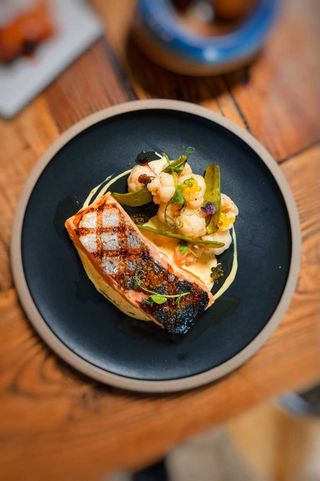 Salmón a la brasa con puré de coliflor especiada y shimeji