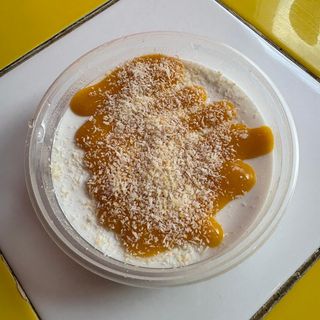 Tarrina de coco con coulis de mango-maracuyá y coco tostado