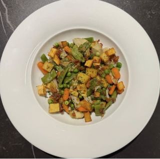 Menestra de verduras salteada con jamón y patata frita