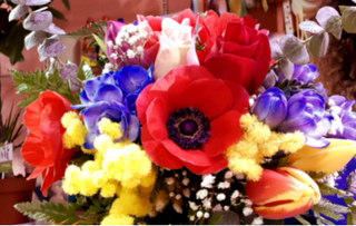 Mazzo rotondo colorato con fiori di stagione e mimosa