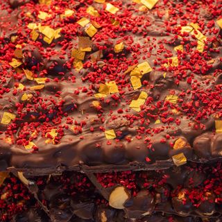 Ciocolata neagra, alune de padure, zmeura liofilizata si foita de aur