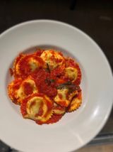 Ravioli relleno de ricota y espinacas con salsa de tomate