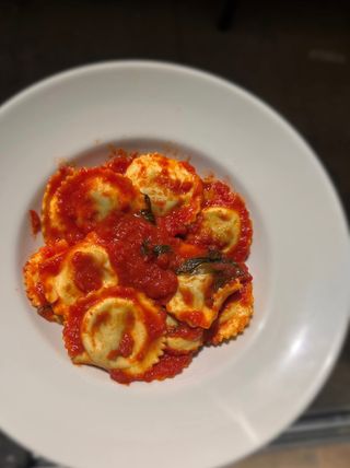 Ravioli relleno de ricota y espinacas con salsa de tomate