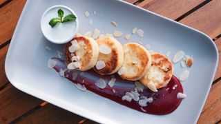 Sirniki sa prelivom od maline i limunovom pavlakom