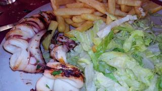 Calamari fritti, patate fritte e insalata verde