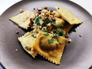 Ravioloni ricotta e porcini con crema al parmigiano, olio aromatico alla nepitella e crumble di guanciale