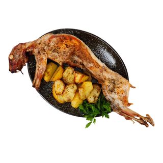 Conejo entero a l'ast con pimientos y patatas