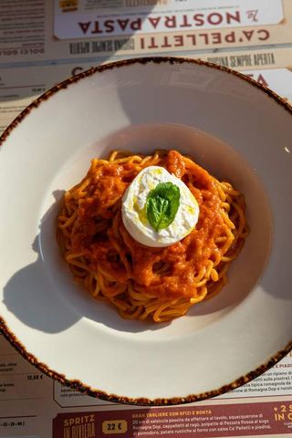 Spaghetti al sugo di pomodoro e basilico con burrata fresca in uscita