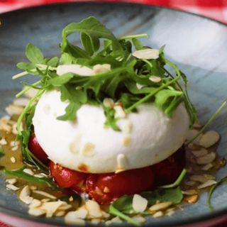 Burrata rellena de pesto con cherry asados y almendras