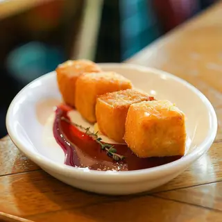 Dados de Brie crujientes con salsa de frutos rojos