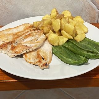 Pechuga de pollo a la plancha con patatas fritas y pimientos verdes.