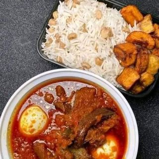 Nigerian beans mixed with white rice, served with beef stew and 2 eggs 